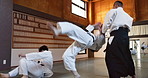 Students in dojo with sensei for aikido training, fitness and development with action, exercise and coaching. Teaching, learning and fighting, traditional Japanese martial arts class with aikidoka.