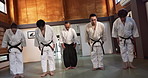Black belt students, bow or sensei in dojo for aikido practice, discipline or self defense. Combat demonstration, Japanese people learning or ready to start training for fighting class or education