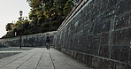 Woman at temple in Japan, walking at wall and reading calligraphy at Naritasan Shinshoji. Japanese culture, spiritual history and carved writing on sidewalk with travel adventure, zen and sightseeing