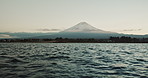 Mountain, nature and landscape with sea, sky and calm horizon on holiday or vacation. Fujiyoshida, Japan and skyline with trees in summer environment with ocean, water or waves on river shoreline