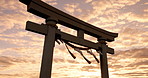 Torii gate, sunset and cloudy sky with zen, peace and spiritual history on travel adventure in Japan. Shinto architecture, Asian culture and calm nature on Japanese landscape with sacred monument.