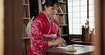 Japanese woman, pen and calligraphy for writing poetry, creativity or art with drawing in home. Girl, person or writer with ink, thinking and ideas with vision, paper and haiku for culture in Tokyo