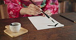 Paintbrush, ink and hands, Asian writing or script with paper, document and creativity, calligraphy and traditional text. Japanese font, writer with black paint and person at desk with art and tools