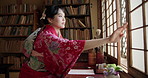 Woman, open window and traditional architecture, fashion and dress in a Japanese tea house or home. Sliding door, light and view in the morning in Asian inspired accommodation with ancient culture