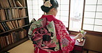 Woman, back and writing with traditional calligraphy, poetry or creativity for art in home library. Girl, person and pen with ink, thinking and idea with vision, paper or haiku for culture in Tokyo