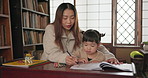 Japanese Mom, child and learning with homework, writing and books for study, development and helping hand. Education, mother and daughter with notes, pen and check progress in family house with study
