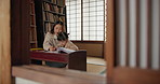 Japanese Mom, girl and education with homework, writing and books for study, development and helping hand. Learning, mother and daughter with notes, pen and check progress in family house with study