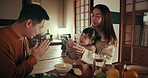 Japanese parents, girl kid and dinner with bow, smile and teaching gratitude with noodles, night and nutrition in home. Child, mother and dad for food, diet and dining room at family house in Tokyo