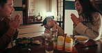 Japanese parents, child and dinner with praying, thinking and care with bonding, night or nutrition in family home. Kid, mother and father with food, diet and faith in dining room at house in Tokyo