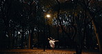 Woman, dancer and ballerina in trees, nature and moving body for fantasy, night and freedom in performance. Person, girl and ballet with dancing, steps and outdoor in dark woods, autumn and forest