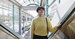 Airport, travel and holiday with asian woman on escalator for trip, journey or international adventure. Vacation, destination or terminal with young passenger person boarding a flight for departure