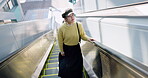 Airport, holiday and asian woman tourist on escalator in terminal for trip, journey or international adventure. Travel, destination or vacation with young passenger boarding a flight for departure