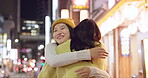 Japanese women, hug and friends in city for travel, bonding and care on weekend vacation in street. People, happy and embrace in tokyo town on holiday, wellness and relax together for social on road