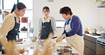 Cooking class, women and learning to cook, chef and japanese food in kitchen, professional and skill. Restaurant, teaching and course for culinary skills, working together and aprons for cleanliness
