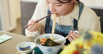 Japanese woman in restaurant, eating noodles and food for lunch or dinner. Ramen, bowl or hands of a young hungry person, customer or girl with chopsticks to enjoy healthy meal or traditional cuisine