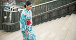 Japanese woman, traditional and walking on stairs in city, travel and wellness on steps for peace attitude outdoor. Person, calm or kimono fashion by urban town or journey in tokyo culture in respect