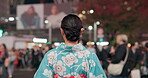 Woman, back and walking in city with kimono, travel and leisure in heritage celebration in positive attitude. Person, smile or traditional clothes by urban town buildings or journey in tokyo culture