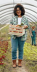 Woman, face and vegetable or box in greenhouse as sustainable business, farming or gardening. Female person, worker and carrots or countryside food environment in agriculture, production or nutrition