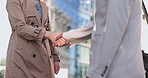 Shaking hands, collaboration and closeup of business people in the city with corporate agreement. Greeting, onboarding and zoom of professional colleagues with handshake for welcome in urban town.