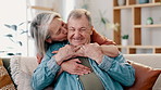 Happy, love and senior couple hug on a sofa with kiss, comfort and bonding at home together. Marriage, support and old people embrace in a living room with trust, respect and gratitude, smile or care