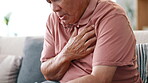 Senior man, heart attack and pain with emergency in home, massage chest and cardiovascular problems. Hands, mature person and coughing with lung disease, anxiety and living room with cardiac arrest