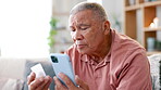 Senior man, pills and cellphone for internet on couch, worry and reading instructions on bottle with confusion. Mature person, medication or digital search on mobile phone or prescription in home