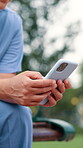 Hands, phone and nurse typing for healthcare service, telehealth or reading email. Smartphone, closeup and medical professional on internet, research and check mobile app for wellness outdoor at park