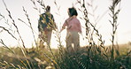 Nature, holding hands and back of couple in a field embracing the sunset with plants, grass and greenery. Love, romance and people with leaves for calm or peaceful environment in countryside.