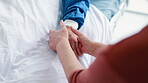 Patient, person and holding hands on hospital bed or care for health problem for medical support, love or empathy. People, fingers and embrace comfort at clinic or marriage compassion, pain or virus