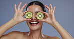 Face, kiwi and woman with natural beauty, vegan or eco friendly product with wellness for skin in studio. Happiness, excited and green fruit, exotic or tropical with cosmetics on grey background