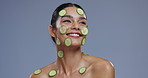 Skincare, cucumber and face of happy woman on blue background for wellness, beauty and cosmetics. Dermatology, spa and person with vegetable for nutrition, organic and natural benefits in studio