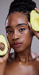 Beauty, avocado and face of woman in studio for healthy cosmetics, nutrition or diet on grey background. Portrait, serious african model or fruit for sustainable dermatology, eco benefits or skincare