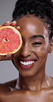 Grapefruit, beauty and face of black woman in studio for vitamin c benefits, nutrition or glow on grey background. Portrait, model or citrus fruits for healthy skincare, sustainable cosmetics or diet