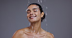 Water drop, skincare and face of woman on gray background for cleaning, wellness and cosmetics. Dermatology, beauty and person with splash for washing, facial treatment and healthy skin in studio