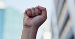 City, closeup and person with protest, fist and human rights with justice, equality and global support. Outdoor, activist or protester with hand gesture, end the genocide or ceasefire with urban town