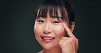 Skincare, serum and face of Asian woman in studio with retinol product, vitamin A and beauty routine. Smile, cosmetic benefits and girl with collagen facial oil for dermatology on dark background.