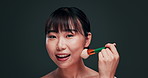 Makeup, brush and Asian woman, beauty and portrait for cosmetology, apply foundation and wellness on grey background. Face, skin and powder with change, cosmetic tools and Japanese model with smile