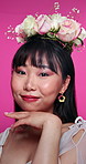 Face, beauty and flowers asian woman at salon in studio on pink background for natural wellness. Portrait, skincare and floral bouquet on hair with happy young person at spa for facial aesthetic