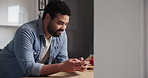 Happy man, phone and typing in kitchen for social media, networking or communication at home. Young male person smile on mobile smartphone for online chatting, texting or research on table at house