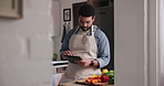 Man, tablet and cooking tutorial with vegetables for research, online class or recipe in kitchen at home. Male person or chef on technology for diet, nutrition or reading up on ingredients at house
