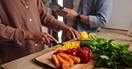 Person, hand and chopping vegetables on board for healthy nutrition salad or dinner, carrots or pepper. Chef, helper and tablet for online recipe in kitchen for prepare ingredients, cook or wellbeing