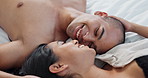 Happy couple, talking in bed with love, intimacy and romance at home for relationship, sex and bonding. Young people, woman and man relax in bedroom with gentle touch and kiss for valentines day