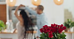 Roses, valentines day and home with couple dancing for love celebration in a kitchen with waltz. Gift, flower present and floral bouquet with happy people with music, marriage and care together