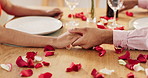 Couple, roses and holding hands on dinner date, anniversary or valentines day dining by table at home. Closeup of man and woman in celebration or care for romantic honeymoon, embrace or love at house