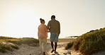 Couple, holding hands and walking on beach, love and bonding together on vacation at sea. Back, people and partnership or support on ocean adventure, date and travel on anniversary and romance