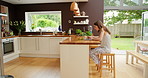 A young businesswoman drinking coffee and working on her laptop at home