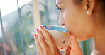 Young woman drinking a cup of coffee at home. Enjoying a relaxing and comforting warm drink