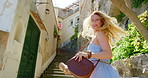 Carefree cheerful young woman running up stairs alone while she's on holiday