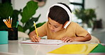 Child, headphones or pencil to learn writing with audio, relax or classical music for creativity in home school. Boy, learning alphabet and podcast tutor for language development and calm in kitchen