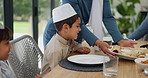 Muslim, family and kids with food or lunch in dining room for eid, islamic celebration and hosting. Ramadan, culture and children eating at religious gathering with roti, dinner or happiness at table